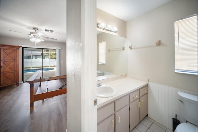 16834 Toledo Blade Blvd, Port Charlotte, FL 33954 - bathroom featuring a ceiling fan, vanity, wainscoting, wood finished floors, and toilet
