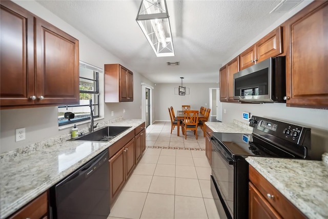 16834 Toledo Blade Blvd, Port Charlotte, FL 33954 - kitchen with black appliances, light tile patterned floors, a sink, light stone counters, and brown cabinetry