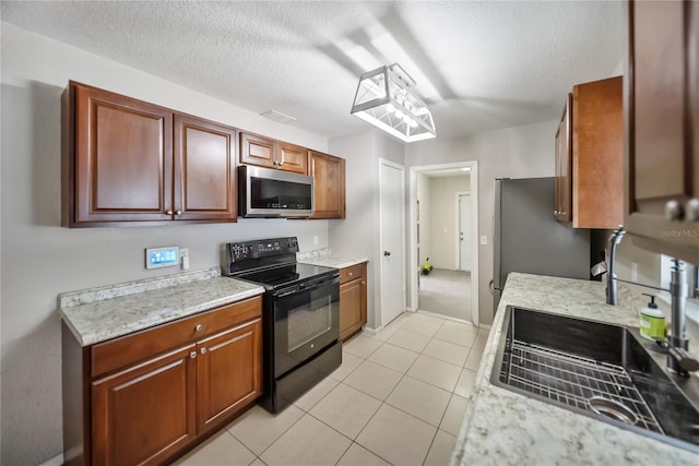 16834 Toledo Blade Blvd, Port Charlotte, FL 33954 - kitchen featuring appliances with stainless steel finishes, light countertops, a sink, light tile patterned flooring, and a textured ceiling