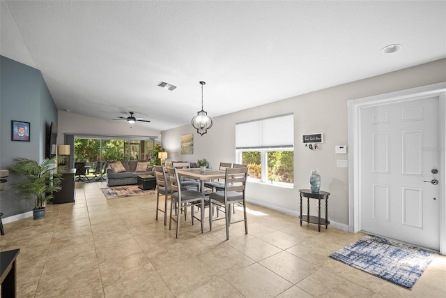 5866 Guarino Dr, Sarasota, FL 34238 - dining area with baseboards, a ceiling fan, vaulted ceiling, and light tile patterned floors