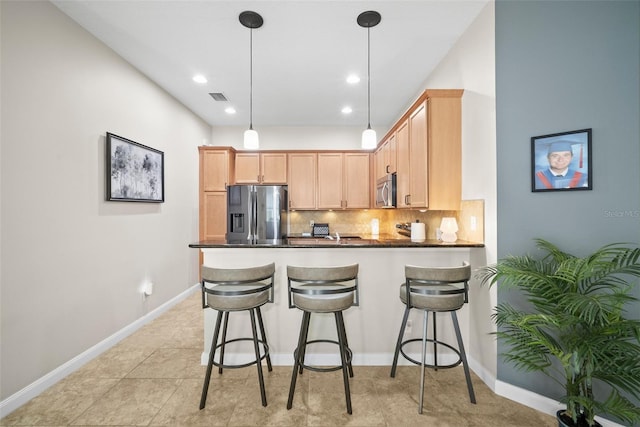 5866 Guarino Dr, Sarasota, FL 34238 - kitchen featuring appliances with stainless steel finishes, dark countertops, a peninsula, backsplash, and baseboards