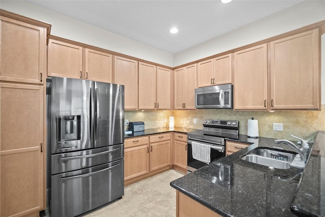 5866 Guarino Dr, Sarasota, FL 34238 - kitchen with stainless steel appliances, a sink, dark stone counters, light brown cabinets, and backsplash
