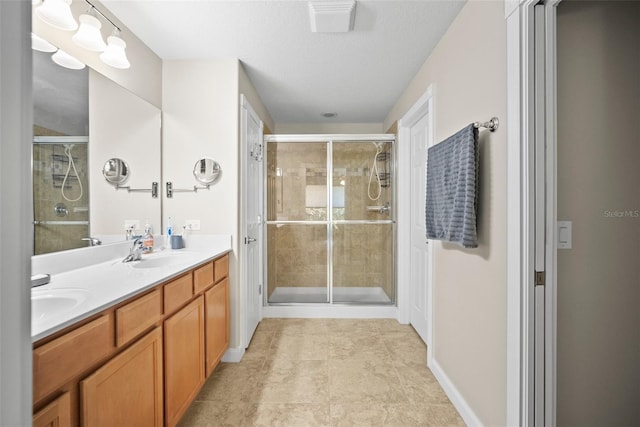 5866 Guarino Dr, Sarasota, FL 34238 - bathroom featuring double vanity, a shower stall, a textured ceiling, and baseboards