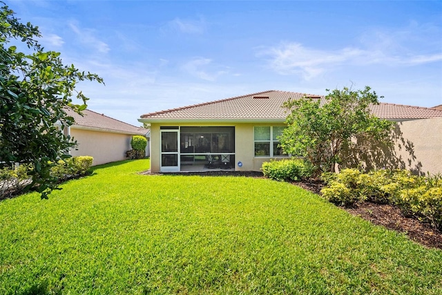 5866 Guarino Dr, Sarasota, FL 34238 - rear view of house featuring stucco siding, a tiled roof, a lawn, and a sunroom