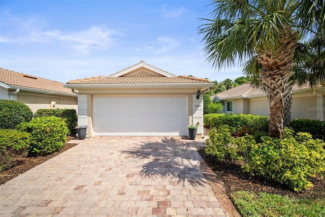 5866 Guarino Dr, Sarasota, FL 34238 - mediterranean / spanish-style home with stucco siding, decorative driveway, and a tiled roof