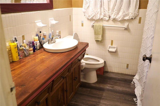 1099 6th Ave NE, Largo, FL 33770 - full bath featuring tile walls, vanity, wood finished floors, toilet, and a wainscoted wall