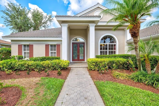 8930 Bloomfield Blvd, Sarasota, FL 34238 - property entrance with french doors, a tile roof, and stucco siding