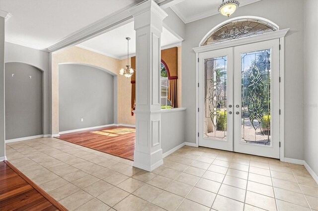 8930 Bloomfield Blvd, Sarasota, FL 34238 - tiled entrance foyer with french doors, a chandelier, ornamental molding, decorative columns, and arched walkways