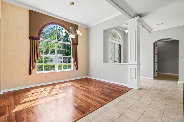 8930 Bloomfield Blvd, Sarasota, FL 34238 - unfurnished room featuring arched walkways, ornamental molding, light wood-type flooring, ornate columns, and a chandelier