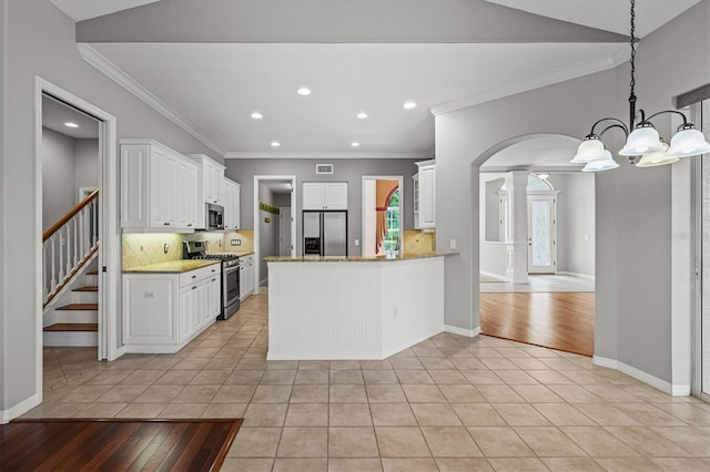 8930 Bloomfield Blvd, Sarasota, FL 34238 - kitchen with stainless steel appliances, decorative columns, light tile patterned floors, crown molding, and recessed lighting