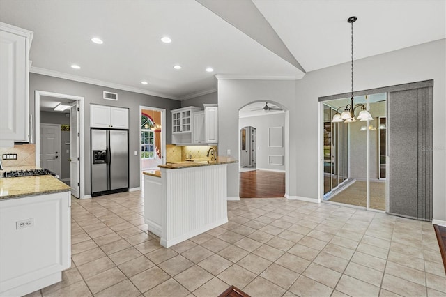 8930 Bloomfield Blvd, Sarasota, FL 34238 - kitchen with stainless steel fridge with ice dispenser, arched walkways, light tile patterned floors, crown molding, and decorative backsplash