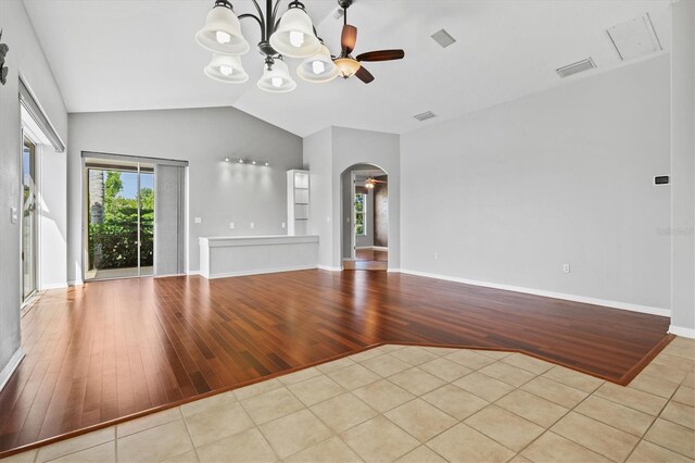 8930 Bloomfield Blvd, Sarasota, FL 34238 - unfurnished living room with arched walkways, wood finished floors, a ceiling fan, lofted ceiling, and a chandelier