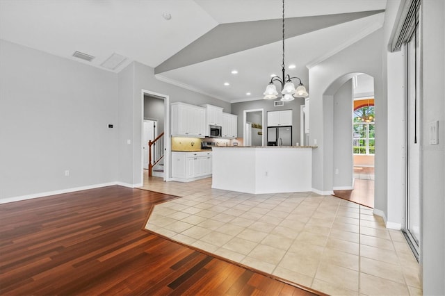 8930 Bloomfield Blvd, Sarasota, FL 34238 - kitchen featuring appliances with stainless steel finishes, crown molding, light wood-type flooring, arched walkways, and white cabinetry