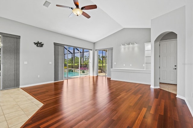 8930 Bloomfield Blvd, Sarasota, FL 34238 - unfurnished living room featuring ceiling fan, lofted ceiling, arched walkways, and wood finished floors