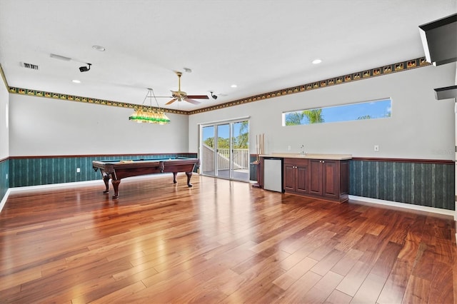 8930 Bloomfield Blvd, Sarasota, FL 34238 - game room featuring a wainscoted wall, wood finished floors, pool table, bar with sink, and recessed lighting