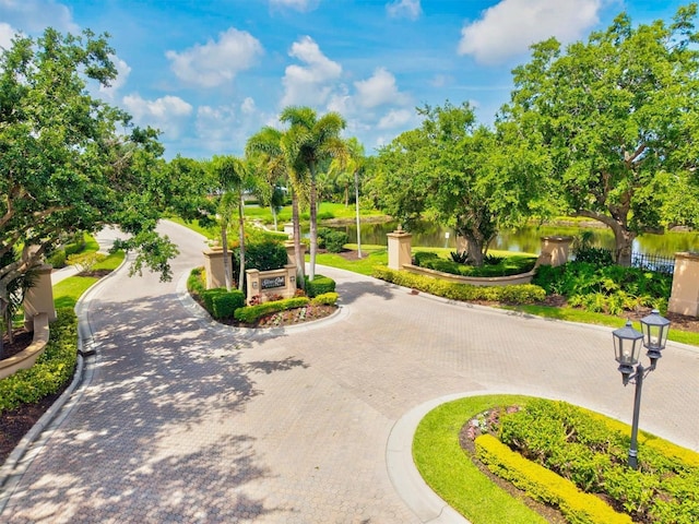 8930 Bloomfield Blvd, Sarasota, FL 34238 - view of community featuring curved driveway, a water view, and view of wooded area