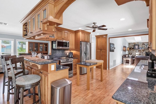 7913 19th Avenue Dr W, Bradenton, FL 34209 - kitchen with stainless steel appliances, ornamental molding, tasteful backsplash, a kitchen bar, and light wood-type flooring