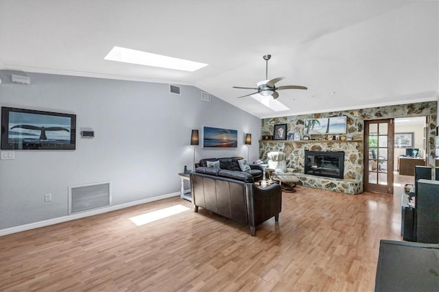 7913 19th Avenue Dr W, Bradenton, FL 34209 - living area featuring a skylight, vaulted ceiling, light wood-style flooring, a ceiling fan, and a stone fireplace