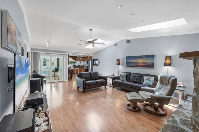7913 19th Avenue Dr W, Bradenton, FL 34209 - living room with vaulted ceiling, light wood-style flooring, a skylight, and ceiling fan