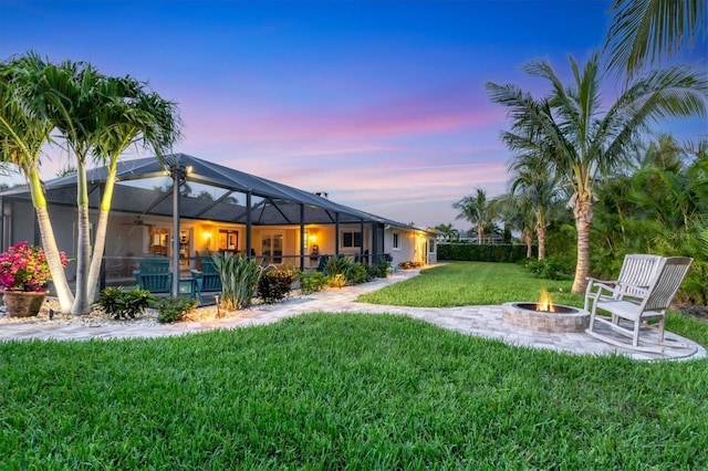 7913 19th Avenue Dr W, Bradenton, FL 34209 - view of grassy yard with an outdoor fire pit, glass enclosure, ceiling fan, and a patio