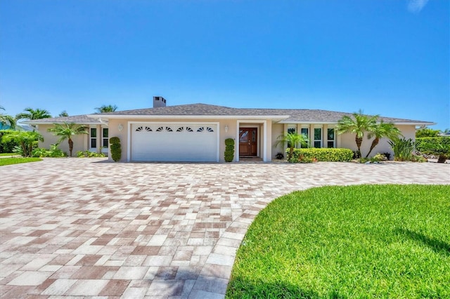 7913 19th Avenue Dr W, Bradenton, FL 34209 - ranch-style home featuring decorative driveway, a garage, a chimney, a front yard, and stucco siding