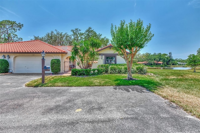 5651 Golf Pointe Dr Unit 5651, Sarasota, FL 34243 - view of front of house featuring a tiled roof, stucco siding, a front lawn, an attached garage, and driveway