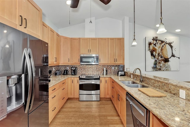 5651 Golf Pointe Dr Unit 5651, Sarasota, FL 34243 - kitchen with stainless steel appliances, a sink, light brown cabinetry, light stone counters, and vaulted ceiling