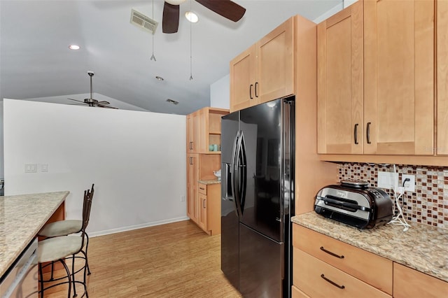5651 Golf Pointe Dr Unit 5651, Sarasota, FL 34243 - kitchen featuring black fridge, light brown cabinetry, a ceiling fan, light wood-style flooring, and backsplash