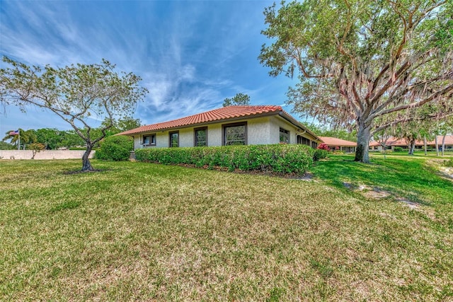 5651 Golf Pointe Dr Unit 5651, Sarasota, FL 34243 - view of front of property with stucco siding, a front yard, and a tiled roof
