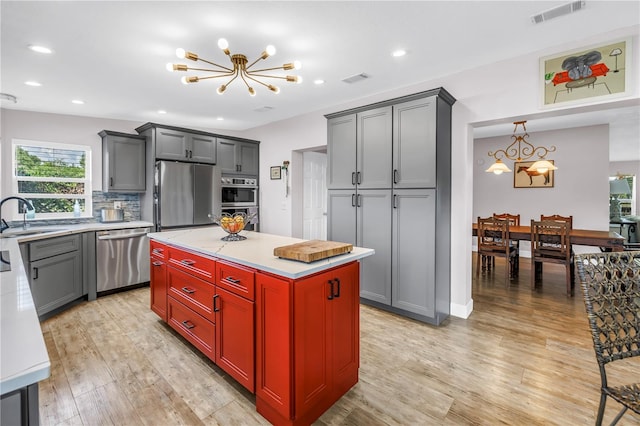 12714 Tyler Run Ave, Odessa, FL 33556 - kitchen with stainless steel appliances, a chandelier, light wood-style flooring, a sink, and recessed lighting
