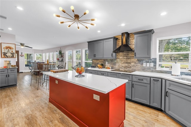 12714 Tyler Run Ave, Odessa, FL 33556 - kitchen featuring wall chimney range hood, gray cabinetry, light wood finished floors, decorative backsplash, and recessed lighting