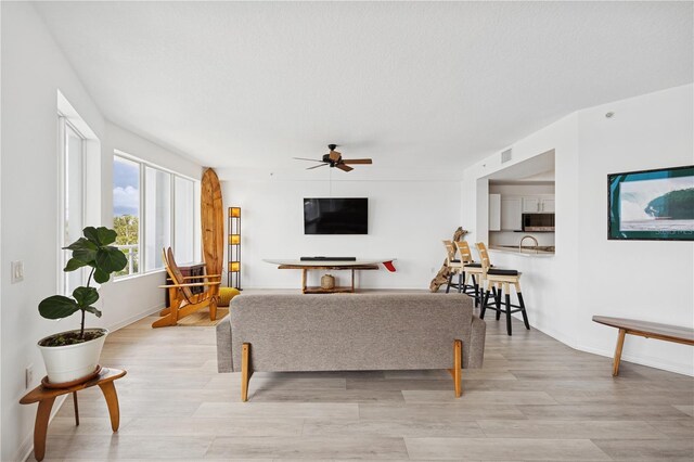 516 Tamiami Trl S Unit 306, Nokomis, FL 34275 - living room featuring ceiling fan, light wood-style floors, and baseboards