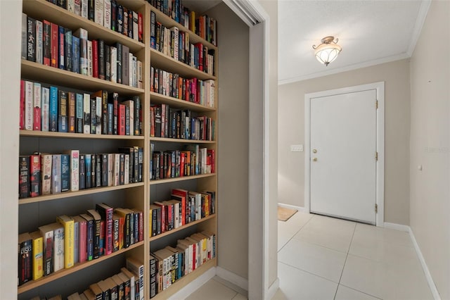 139 Adair Ave, Sarasota, FL 34243 - living area featuring baseboards, crown molding, bookshelves, and tile patterned floors