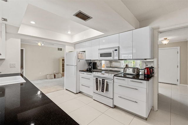 139 Adair Ave, Sarasota, FL 34243 - kitchen featuring white appliances, dark countertops, white cabinetry, a sink, and modern cabinets