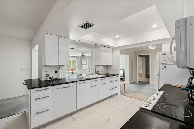 139 Adair Ave, Sarasota, FL 34243 - kitchen featuring a ceiling fan, a tray ceiling, white appliances, white cabinets, and dark countertops