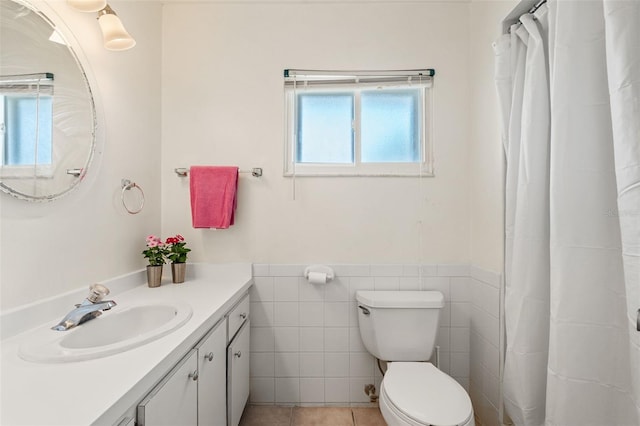 139 Adair Ave, Sarasota, FL 34243 - full bathroom featuring vanity, toilet, a wainscoted wall, tile walls, and tile patterned flooring