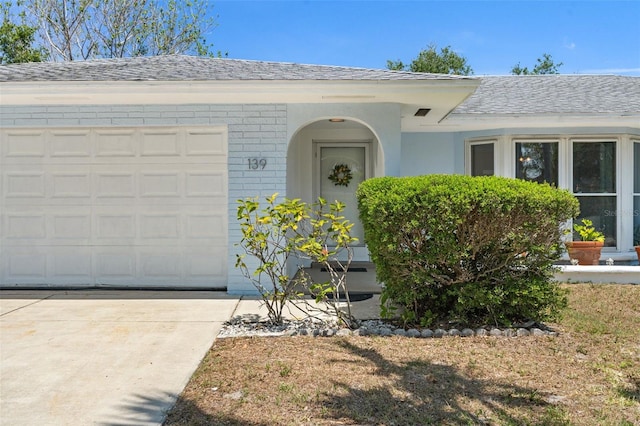 139 Adair Ave, Sarasota, FL 34243 - view of front of home featuring a garage, driveway, and roof with shingles