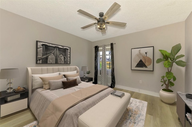 5742 39th Street Cir E, Bradenton, FL 34203 - bedroom featuring light wood-style flooring, a textured ceiling, ceiling fan, and baseboards