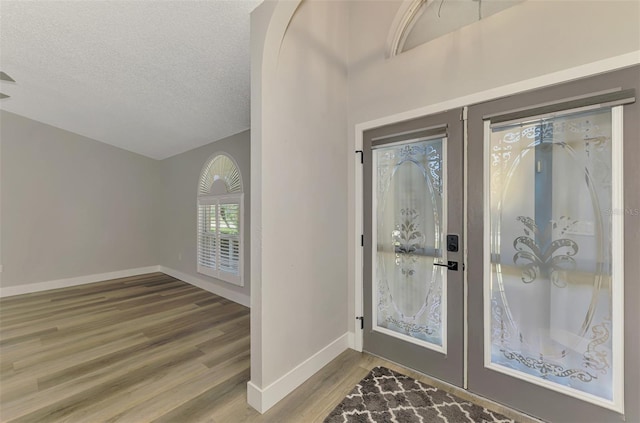 5742 39th Street Cir E, Bradenton, FL 34203 - entrance foyer featuring wood finished floors, baseboards, a textured ceiling, and french doors