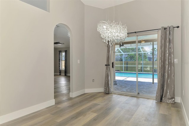 5742 39th Street Cir E, Bradenton, FL 34203 - unfurnished dining area with arched walkways, wood finished floors, and baseboards
