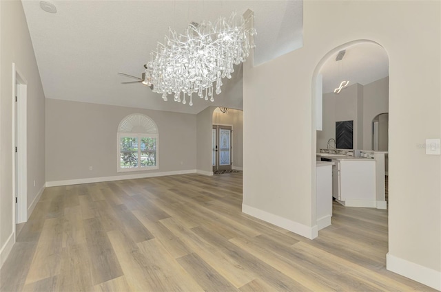5742 39th Street Cir E, Bradenton, FL 34203 - spare room featuring arched walkways, light wood finished floors, a chandelier, and baseboards