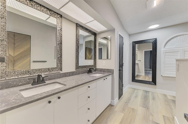 5742 39th Street Cir E, Bradenton, FL 34203 - full bathroom with wood finished floors, double vanity, baseboards, and backsplash