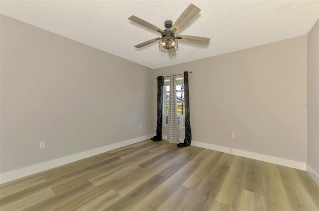 5742 39th Street Cir E, Bradenton, FL 34203 - spare room with light wood-style flooring, ceiling fan, a textured ceiling, and baseboards