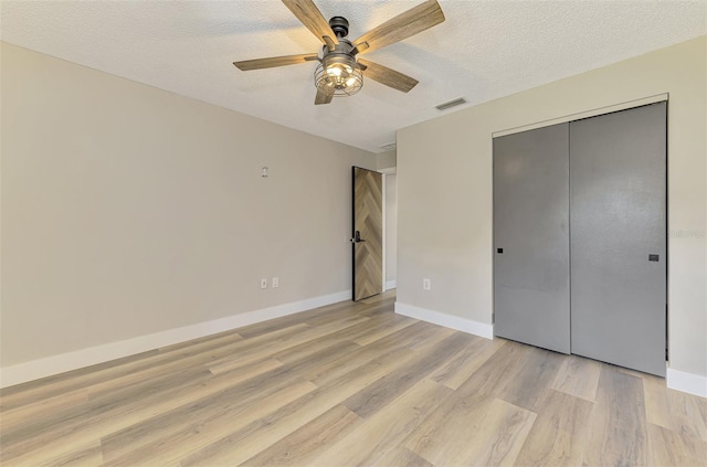 5742 39th Street Cir E, Bradenton, FL 34203 - unfurnished bedroom with light wood-type flooring, a textured ceiling, baseboards, a closet, and a ceiling fan