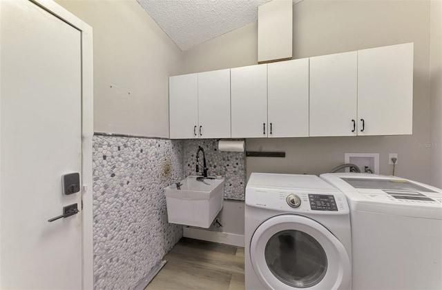 5742 39th Street Cir E, Bradenton, FL 34203 - laundry area with cabinet space, washer and dryer, light wood-style floors, and a textured ceiling