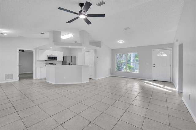 1062 Blossom Dr, Sebastian, FL 32958 - unfurnished living room featuring lofted ceiling, light tile patterned floors, a textured ceiling, ceiling fan, and baseboards
