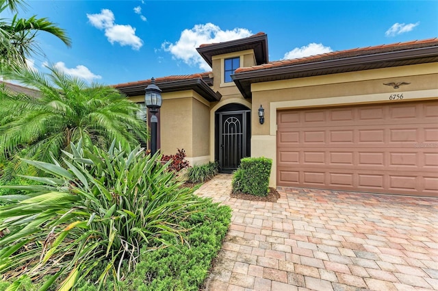 6756 Chester Trl, Lakewood Ranch, FL 34202 - view of front of house featuring stucco siding, a tile roof, decorative driveway, and a garage