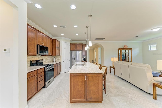 6756 Chester Trl, Lakewood Ranch, FL 34202 - kitchen featuring stainless steel appliances, open floor plan, arched walkways, ornamental molding, and a kitchen bar