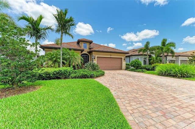 6756 Chester Trl, Lakewood Ranch, FL 34202 - mediterranean / spanish house featuring an attached garage, decorative driveway, a front lawn, stucco siding, and a tiled roof