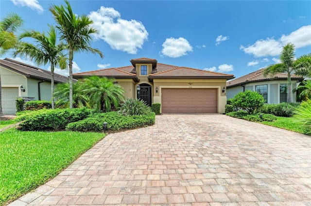 6756 Chester Trl, Lakewood Ranch, FL 34202 - mediterranean / spanish-style house featuring decorative driveway, an attached garage, stucco siding, a tile roof, and a front yard